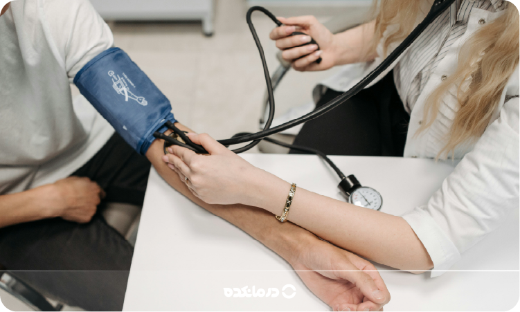 تصویر بیماری که پزشک فشار خون او را اندازه میگیرد را می بینید