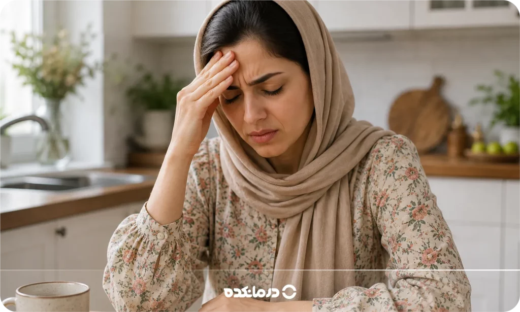 تصویر یک خانم که به دلیل درد، دستش روی ناحیه پیشانیاش قرار گرفته را می بینید