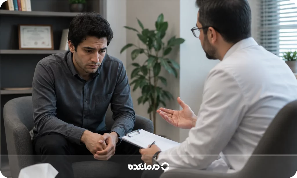 تصویر روانپزشک در حال صحبت با بیماری که چهره ناراحت دارد را می بینید