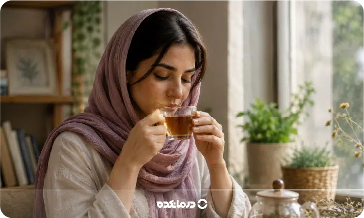 تصویر خانمی که در حال نوشیدن دمنوش است را می بینید
