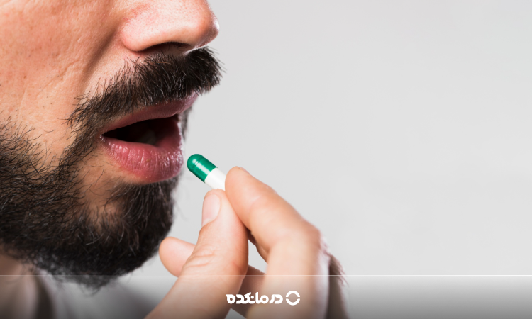 تصویر فردی که در حال خوردن قرص است را می بینید